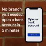 スマートフォンでオンライン銀行口座を5分で開設できることを示す画像。レンガ壁を背景に「No branch visit needed, open a bank account in 5 minutes」と表示。