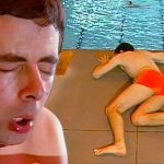 プールの高い飛び込み台でためらいながら立つミスタービーン。